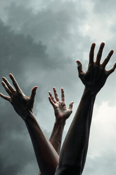 hands stretched out to dark overcast sky