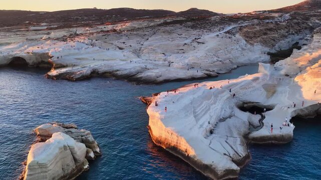 Iconic drone view of Sarakiniko beach at sunrise, famous beach on Milos island in the Mediterranean sea drone shot, vacation in Greece, tourism in the Cyclades, morn8ng aerial view of Milos island