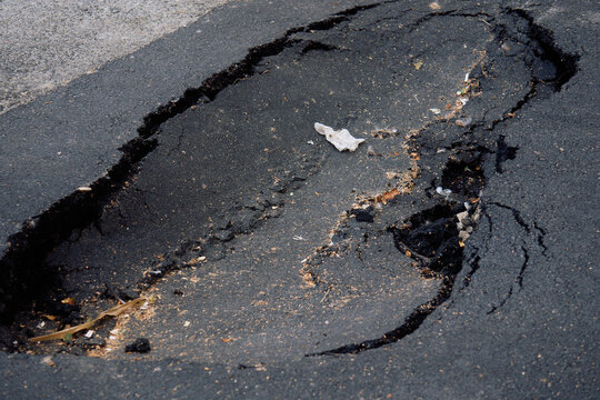 Broken Road Surface showing Deep Asphalt Damage