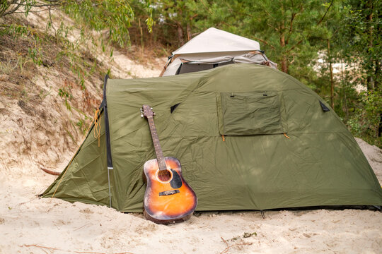 The guitar is standing by the tent camp.