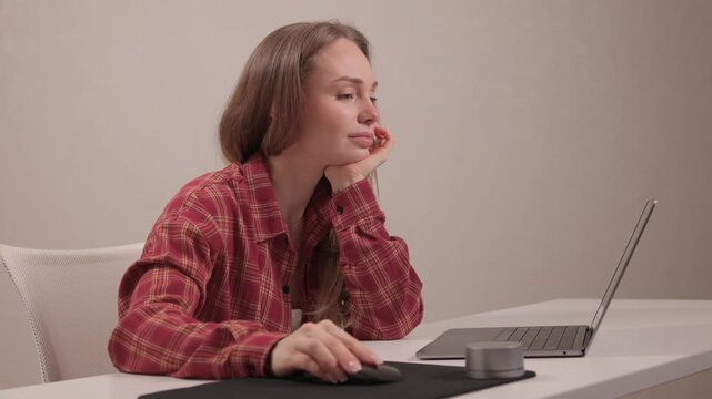 Young lady editing content from home. Female professional concentrating on digital editing task. Young woman in casual attire diligently working on her laptop at home
