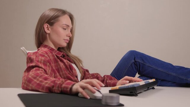 Focused woman typing on keyboard. Woman engaged in remote writing tasks. Female professional diligently performing editing and writing activities with organized workspace