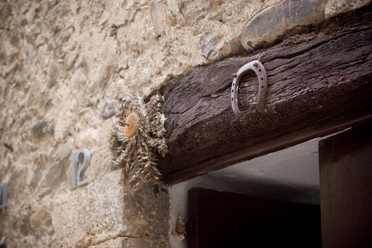 Horseshoe and dry flower amulet on stone wall