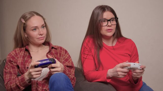 Women play games. Relaxed friends enjoying video games with cheerful interactions. Two women engage in friendly game night amid comfortable surroundings and joyful laughter