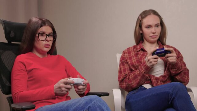 Women play games. Relaxed friends enjoying video games with cheerful interactions. Two women engage in friendly game night amid comfortable surroundings and joyful laughter