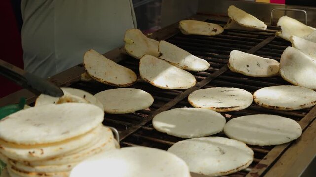 chef hand brushing butter on traditional corn arepas on grill 60fps 4k