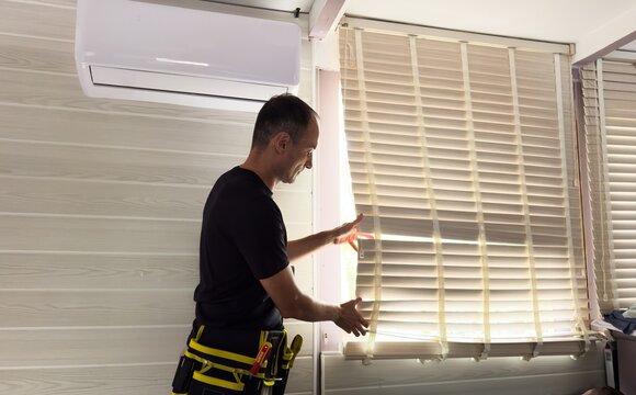 Male hands installing roller blinds on window 