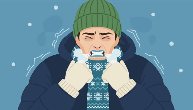 Young man shivering from extreme cold weather wearing a winter jacket, hat, gloves, and a patterned scarf.