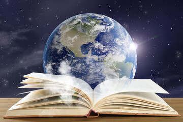 Obraz premium Open book on table against planet in space