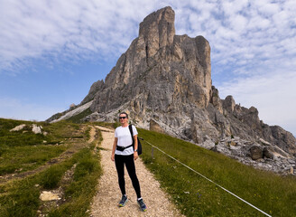 Obraz premium tourists walking in the dolomites at giau pass in summer italy