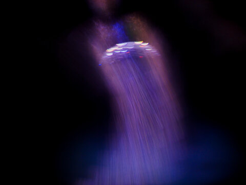 Abstract motion blur captures swirling purple light against dark background. Ethereal glow suggests cosmic, digital, or dreamlike atmosphere. Perfect for futuristic, fantasy