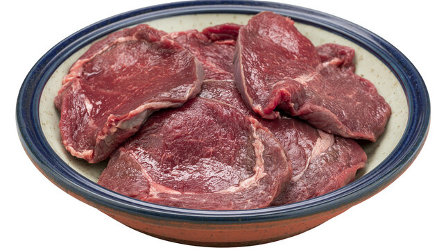 Isolated fresh raw beef steaks in a ceramic bowl ready for cooking or preparing meal