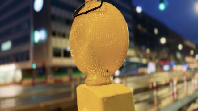 Wet Post Blinking Construction light With Blurred Rainy Helsinki City at Night