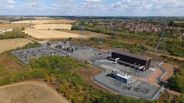 Aerial view of the Eaton Socon Substation and Battery Energy Storage System with electrical infrastructure and power lines set within a rural landscape in St. Neots, England, United Kingdom.