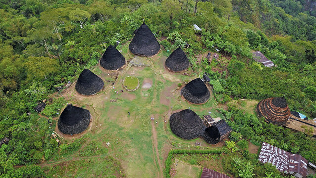 Top down aerial perspective of circular village layout with cone roofs in Wae Rebo