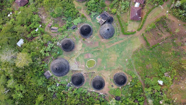 Aerial view of authentic Mbaru Niang thatch houses nestled in tropical mountain forest
