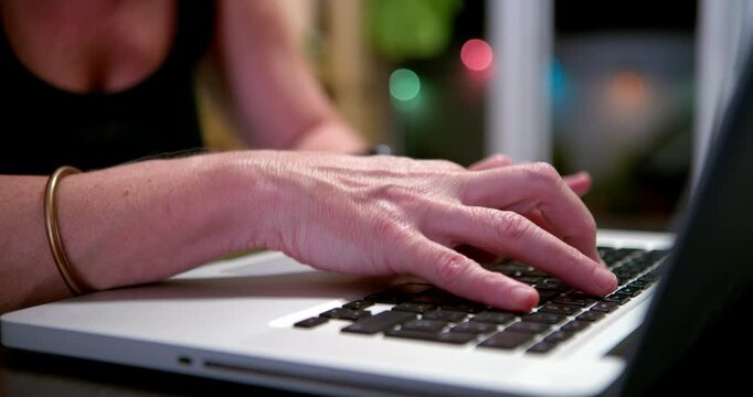 Typing on Laptop: A close-up shot captures a woman's hands busily typing on a laptop keyboard, her focus intently on the screen as she works or communicates.