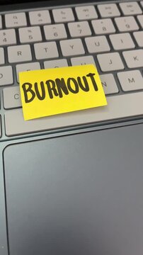 Burnout sticky note on laptop keyboard workplace stress
