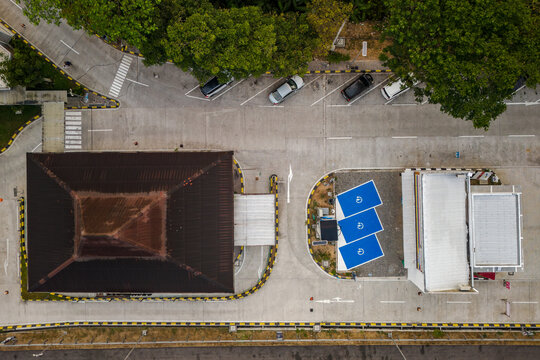 Aerial view of a rest area with a dark roof, electric vehicle charging stations, and parked cars in a paved lot in Salatiga, Central Java, Indonesia.