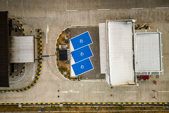 Aerial view of an electric vehicle charging station with three blue parking spots at a rest area in Salatiga, Central Java, Indonesia.