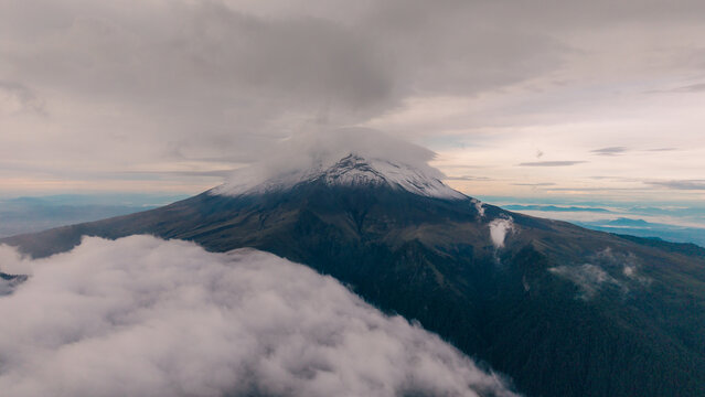 Aerial view of Parque Nacional Iztaccihuatl - Popocatepetl with snow-capped peaks, volcanic slopes, and thick clouds at sunset in Amecameca de Juarez, Estado de Mexico, Mexico.