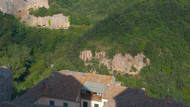 Scenic aerial pan revealing the village of sorano, italy. Stunning aerial view of the medieval village of sorano, known as the matera of tuscany, revealing its ancient houses carved into the tufa rock