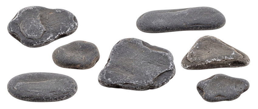Black river stones smooth pebbles set isolated on black background for spa zen design, dark grey natural rock collection, basalt mineral texture, balanced pebble elements, cutout surface material.
