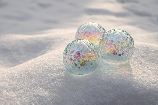 Colorful glass balls placed on white snow during winter