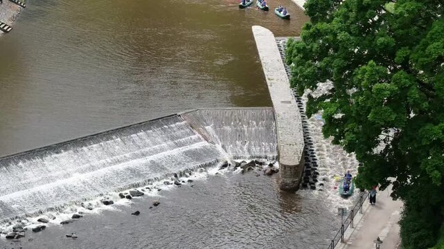 Aerial view of Vltava River weir in Cesky Krumlov with people canoeing and walking