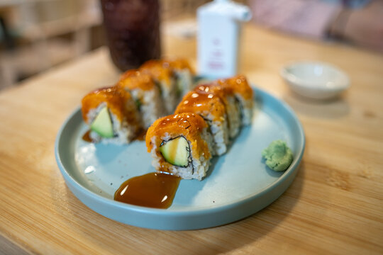Avocado sushi rolls with sauce and wasabi on a plate in Barcelona