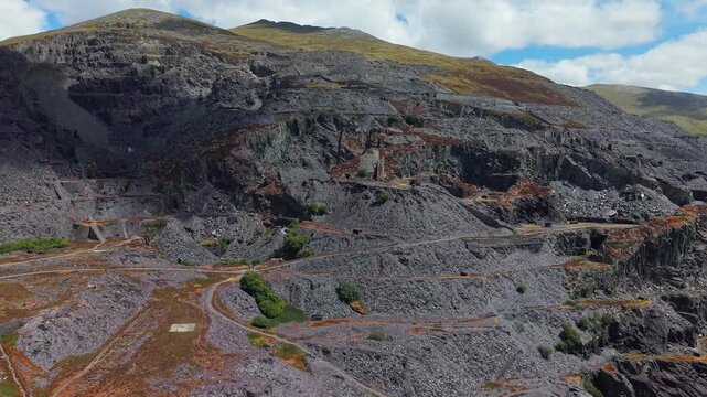 Abandoned Dinorwic slate quarry terraces near Llanberis in Eryri Snowdonia, stepped levels and slate waste heaps rising up mountain slope, aerial view