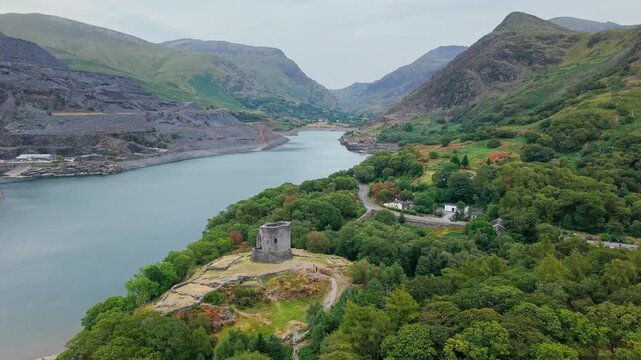 Dolbadarn Castle ruins standing on a grassy hill above Llyn Peris lake, Llanberis, Snowdonia National Park, North Wales, aerial shot