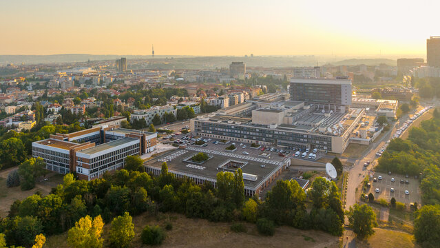 Aerial view of the Czech Television headquarters complex with modern buildings, satellite dishes, and parking areas surrounded by lush greenery in Prague, Hlavni mesto Praha, Czechia.