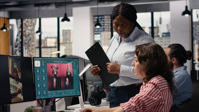 Diverse team uses generative models for text to image editorial content while an AI virtual assistant creates a photography prompt beside a video streaming platform on a computer monitor in an office.