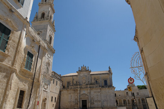 exterior view of the santa maria assunta cathedral of lecce, apulia. italian baroque architecture intricate limestone carvings and decorative stone details under a clear sky