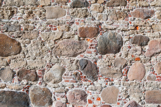 The photo shows a wall made of old brick and stone