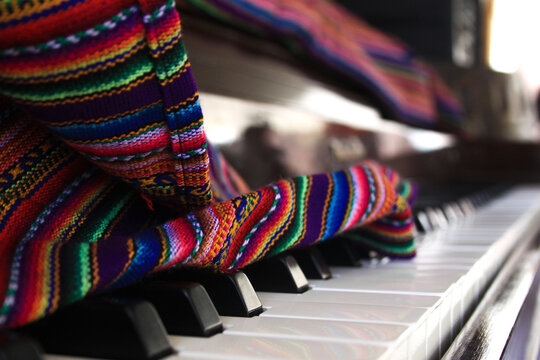 Toma a detalle de un piano decorado con sabanas coloridas