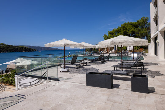 Sun loungers and umbrellas on a luxury hotel resort terrace near the sea