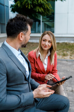 Business discussion between two professionals outside a modern office