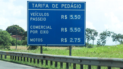 Blue toll tariff board listing rates for cars, commercial vehicles and motorcycles © photochamie