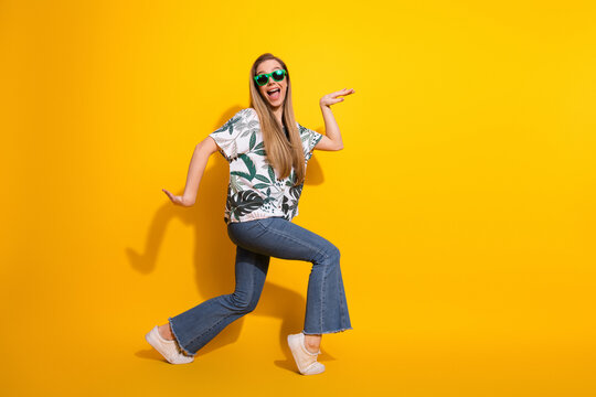 Funny young woman in casual fashion with printed shirt posing cheerfully with style against bright yellow background