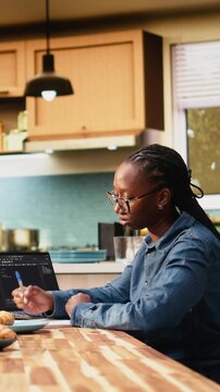Vertical frame: Woman programmer develops web code with software systems on laptop, coding and debugging UX processes while working remotely from home in software development.
