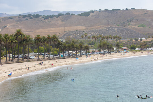 wide angle shots of Refugio Beach in Santa Barbara, California with surfers, palm trees, and mountains in the background