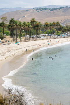 wide angle shots of Refugio Beach in Santa Barbara, California with surfers, palm trees, and mountains in the background