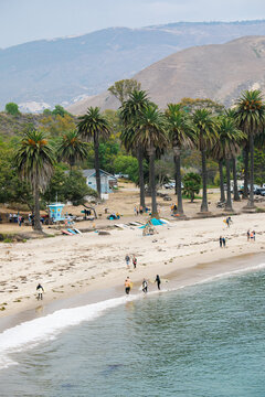 wide angle shots of Refugio Beach in Santa Barbara, California with surfers, palm trees, and mountains in the background