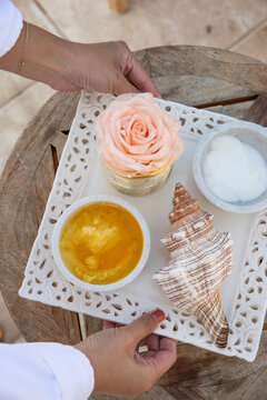 female hands setting down tray of wellness oils and lotions for luxury seaside massage