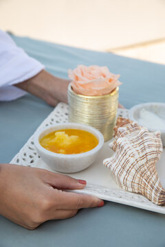female hands setting down tray of wellness oils and lotions for luxury seaside massage