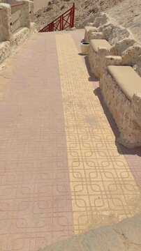Stone pathway with patterns and rustic bench in sunlit outdoor setting Egypt. Hurghada