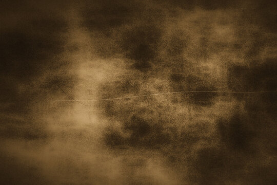 Vintage brown grunge background featuring dramatic smoky clouds and a thin horizontal scratch ideal for retro posters and antique style card designs.