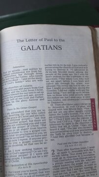 Opening to the book of Galatians of the New Testament in the Holy Bible. New Revised Standard Version. Vertical video.